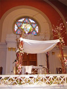 A Jewish marriage ceremony is traditionally carred performed under a chuppah (wedding canopy). Here a chuppah, decorated with blossom, has been erected inside a synagogue and awaits the bridal couple.