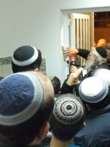 A mezuzah being affixed to the door post during a Chanukat haBayit ceremony