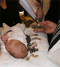 A baby at his Pidyon haBen. Here the ceremony is performed according to Sephardi custom, indicated by the jewellery placed alongside the baby.